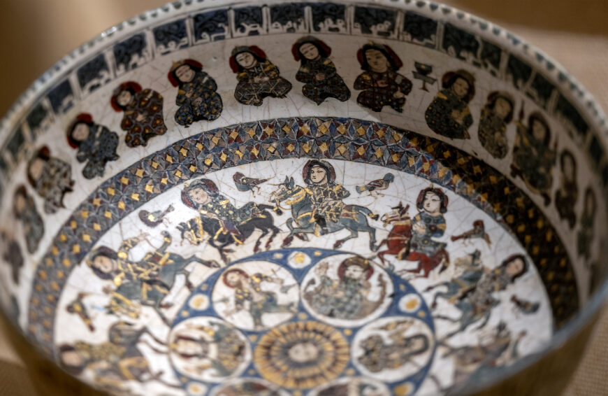 Bowl with Courtly and Astrological Motifs, late 12th–early 13th century (Central or Northern Iran), stonepaste, polychrome inglaze and overglaze painted and gilded on opaque monochrome glaze, 9.5 x 18.7 cm (The Metropolitan Museum of Art, New York)